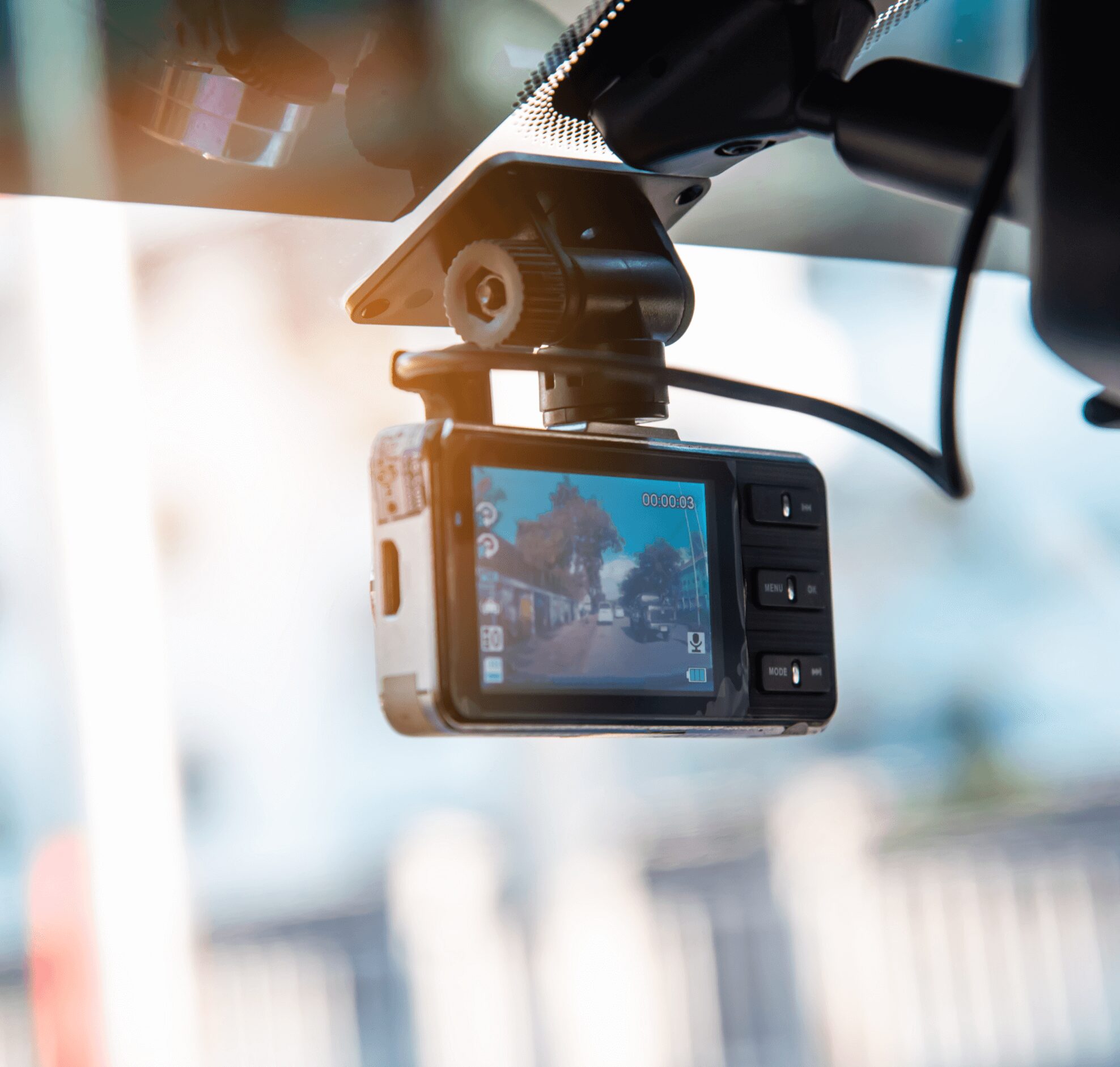 A car camera is hanging on the windshield.