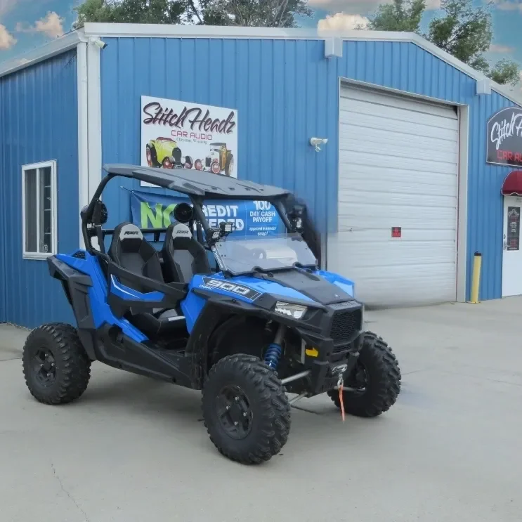 A blue and black atv parked in front of a building.